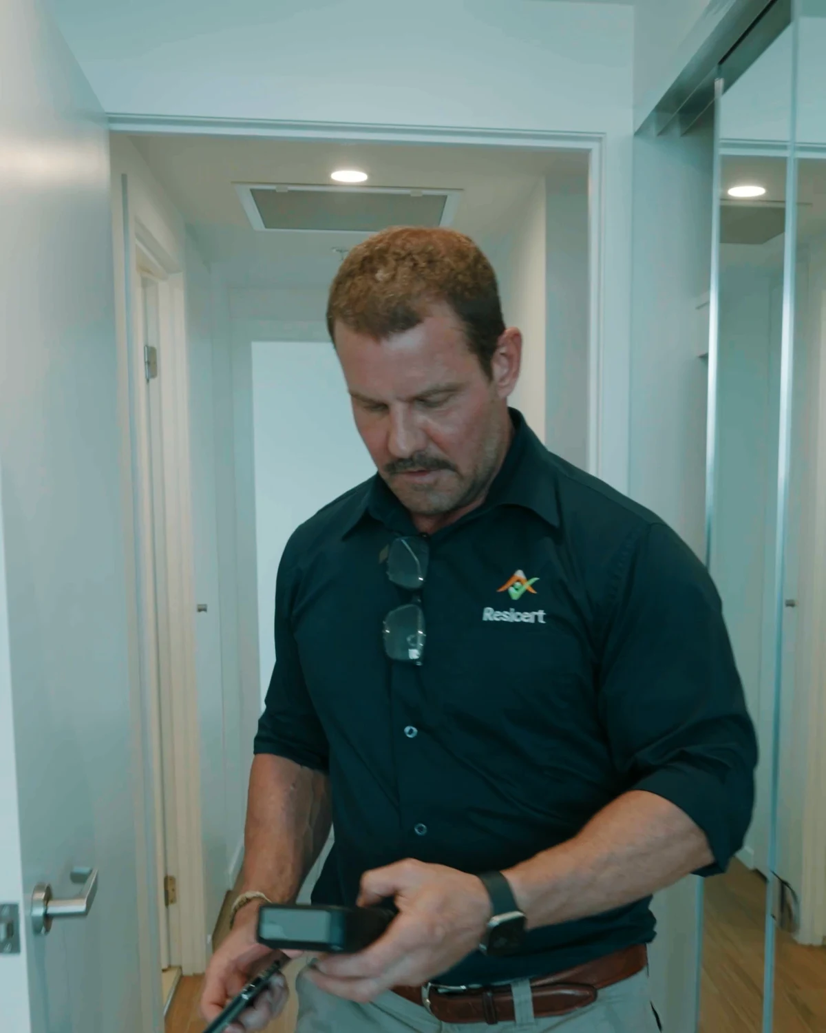 Paul Klumper in a hallway checking his inspection device